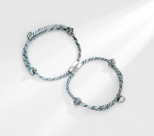 Close-up of magnetic heart charms on braided friendship bracelets for couples