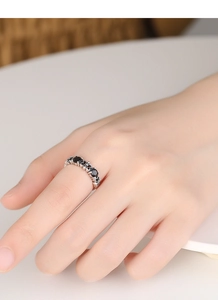 Detailed side view of vintage S925 silver ring featuring black gems and hollow heart patterns