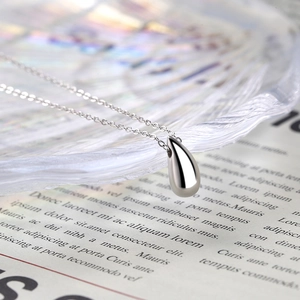 Détail macro du collier pendentif goutte en argent poli avec finition miroir