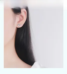 Minimalist S925 sterling silver four-leaf clover stud earring on a female model ear