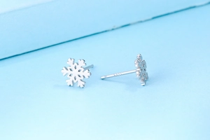Macro des boucles d'oreilles flocon en argent sterling S925 montrant le poinçon d'authenticité