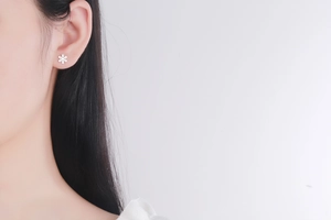 Détail d'une boucle d'oreille flocon de neige en argent portée par un mannequin pour le style