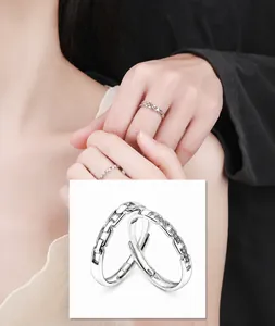 Close-up of interlocking sterling silver couple rings with pavé zircon and open band detail