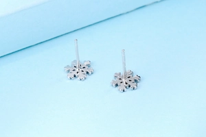 Gros plan de boucles d'oreilles flocon en argent sterling S925 avec poinçons visibles