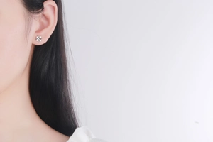Close-up of minimalist S925 sterling silver four-leaf clover stud earring on model ear