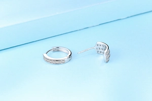 Detailed macro view of S925 sterling silver stamp and baguette-cut zircons on hoop earrings