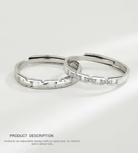 Close-up of interlocking silver couple rings with pavé cubic zirconia and chain texture