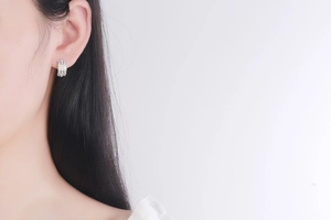 Close-up of S925 silver hoop earrings with sparkling zircon stones on a model ear