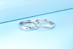 Detailed view of S925 silver Mobius rings with sparkling cubic zirconia on light blue background