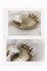 Detail of S925 sterling silver ball ring with cross hanging charm on a tray
