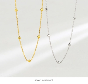 Detailed close-up of gold and silver choker necklaces featuring delicate spacer beads