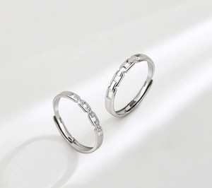 Detailed view of s925 silver interlocking couple rings with hollow chain and pavé stones