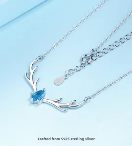 Macro shot of S925 sterling silver deer necklace with a drop-shaped blue crystal