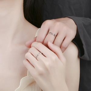 Matching silver chain link couple rings with crystal accents on female model hand