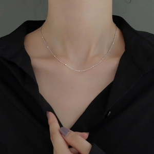 Minimalist silver beaded choker necklace for women shown on a model neck with black shirt