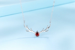 Detailed macro view of S925 silver elk antler necklace with a red teardrop gemstone
