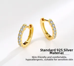 Close-up of gold-plated S925 sterling silver huggie earrings with sparkling clear cubic zirconia