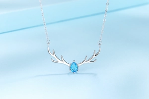 Macro detail of S925 sterling silver deer antler necklace with blue teardrop gemstone