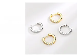 Macro detail of gold and silver S925 sterling silver huggie earrings with cubic zirconia