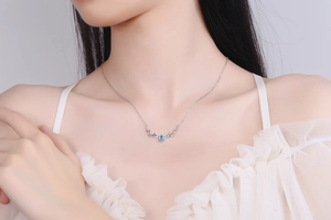 Detail of S925 sterling silver deer antler necklace featuring a teardrop blue crystal gem