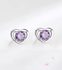 Dettaglio orecchini a cuore in argento con zircone viola e design traforato