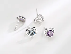 Dettaglio di orecchini a cuore in argento S999 con zirconi bianchi e viola brillanti