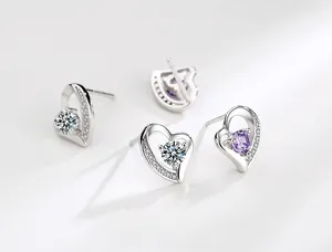 Vista dettagliata di orecchini a cuore in argento con pietre bianche e viola brillanti