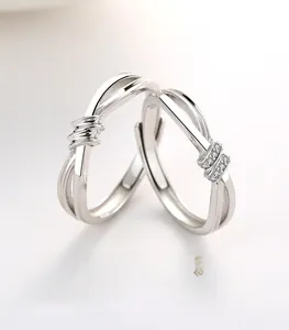 Détail de bagues de couple en argent S925 avec nœud concentrique et incrustation de zircon
