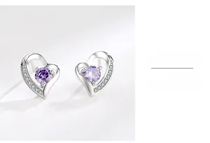 Primo piano di orecchini a cuore in argento S999 con gemme viola e dettagli in diamanti