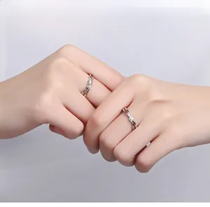 Détail de bagues de couple en argent S925 avec design de nœud et zircons scintillants
