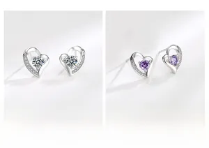 Dettaglio di orecchini a cuore in argento con pietre preziose bianche e viola brillanti