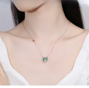 Collier cerf en or rose avec fond vert texturé et petit détail d'étoile scintillante