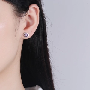Orecchini a cuore in argento S999 con zircone viola indossati da una modella