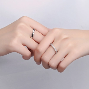 Elegant pair of S925 sterling silver couple rings with sparkling diamond accents on model's hand