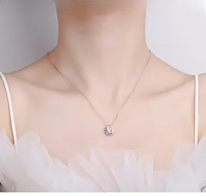 Détail du collier lune en or rose avec émail bleu et zircons brillants sur mannequin