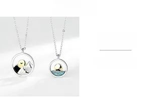 Detailed macro view of S925 sterling silver couple necklaces with sun and mountain motifs