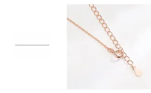 Détail d'une chaîne d'extension de 5 cm en or rose avec fermoir mousqueton et pendentif