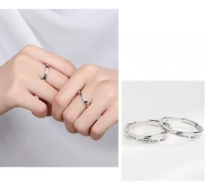 Détail de bagues de couple en argent S925 avec gravure 'you complete me' et poinçon argent