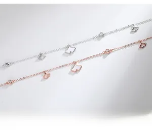Detail of silver and rose gold ginkgo leaf anklets with white shell inlays and zircons