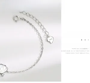 Vue macro d'un bracelet en argent S925 avec pendentif coquille et fermoir à ressort
