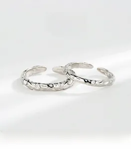 Detailed close-up of S925 sterling silver couple rings with irregular hammered texture