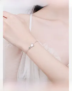 Gros plan d'un bracelet en argent S925 avec pendentif en nacre sur le poignet