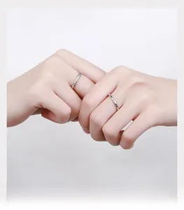 Detail of S925 sterling silver couple rings with irregular sugar paper texture on hand
