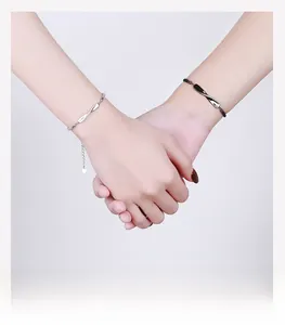 Detail shot of Mobius infinity couples bracelets on entwined hands for Valentines gift