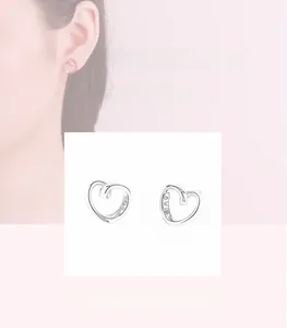 Dettaglio di orecchini a cuore in argento con incisione LOVE sul bordo laterale