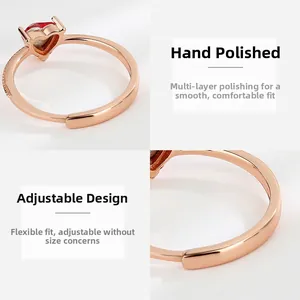 Detail of rose gold heart ring with red stone and adjustable open band design