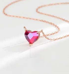 Close-up of heart-shaped red zircon pendant on elegant 18K rose gold necklace chain