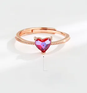 Macro detail of red heart-shaped gemstone ring with rose gold beaded band