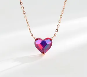 Detailed view of heart-shaped ruby crystal necklace with rose gold chain and gradient hues