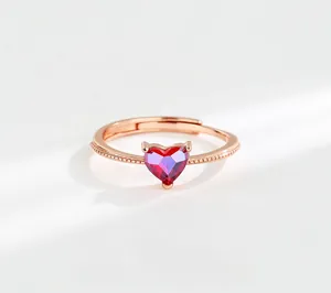 Detail of rose gold heart ring featuring red gemstone and intricate beaded texture
